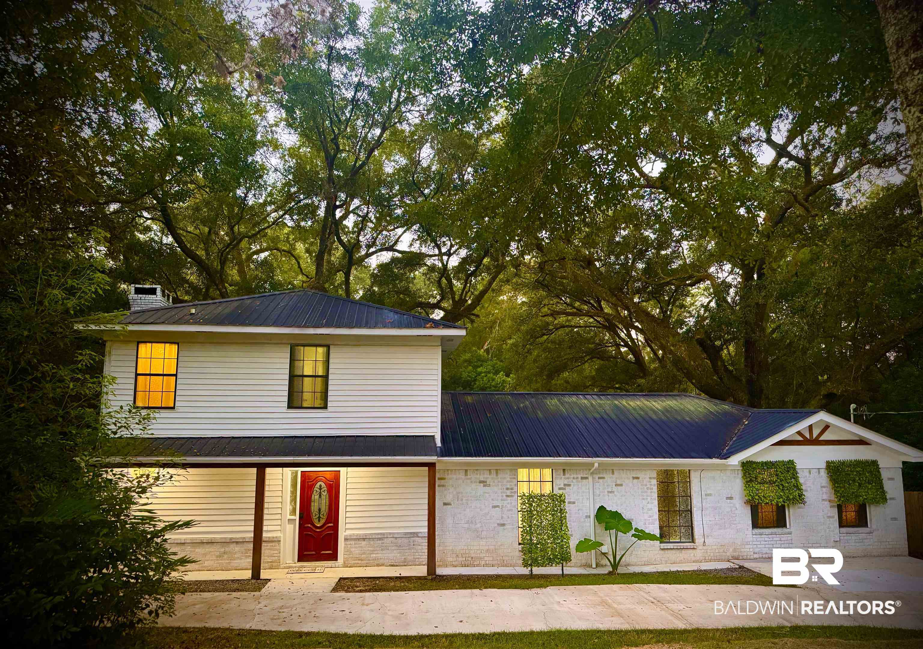 1302 Oak Street Daphne, AL 36526 - Photo 1 of 34 View of front facade featuring a metal roof, brick siding, and a chimney