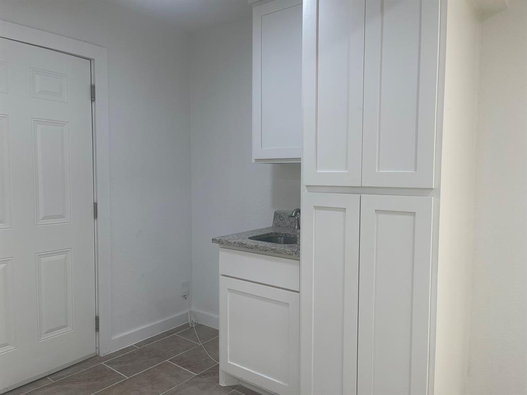 2512 East Overton Road Dallas, TX 75216 - Photo 12 of 21 a kitchen with white cabinets and white appliances