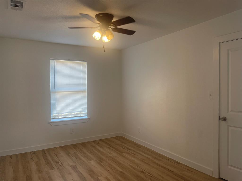 2512 East Overton Road Dallas, TX 75216 - Photo 15 of 21 an empty room with a window and a fan