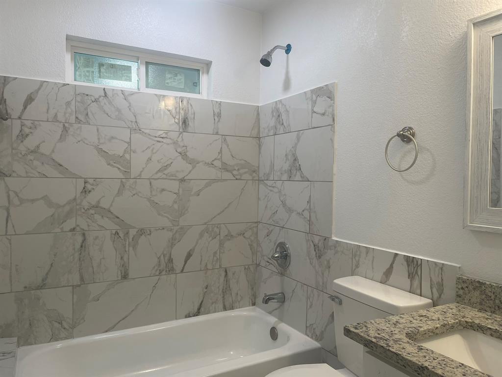 2512 East Overton Road Dallas, TX 75216 - Photo 17 of 21 a bathroom with a granite countertop sink a toilet and bathtub