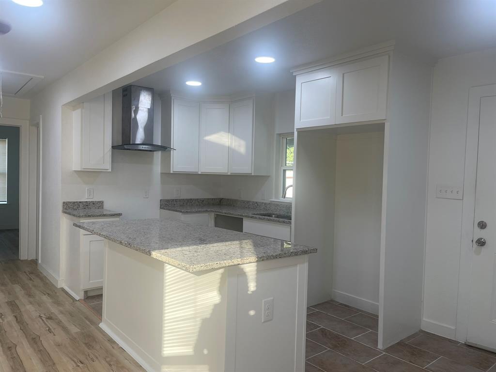 2512 East Overton Road Dallas, TX 75216 - Photo 9 of 21 a kitchen with kitchen island granite countertop a sink and a stove top oven