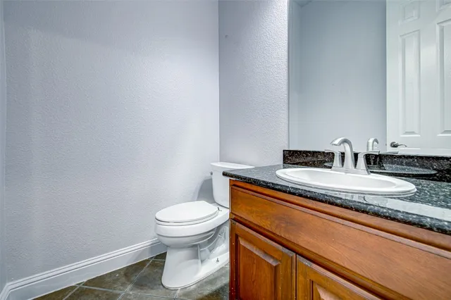 a bathroom with a granite countertop toilet and a sink