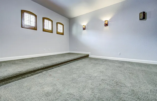 an empty room with windows and cabinet