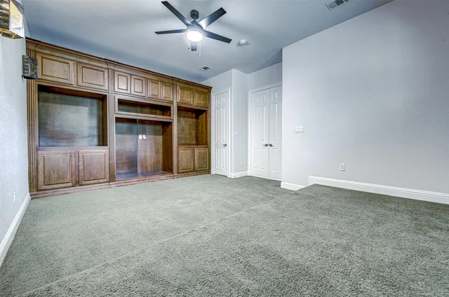 a view of an empty room with window and cabinet