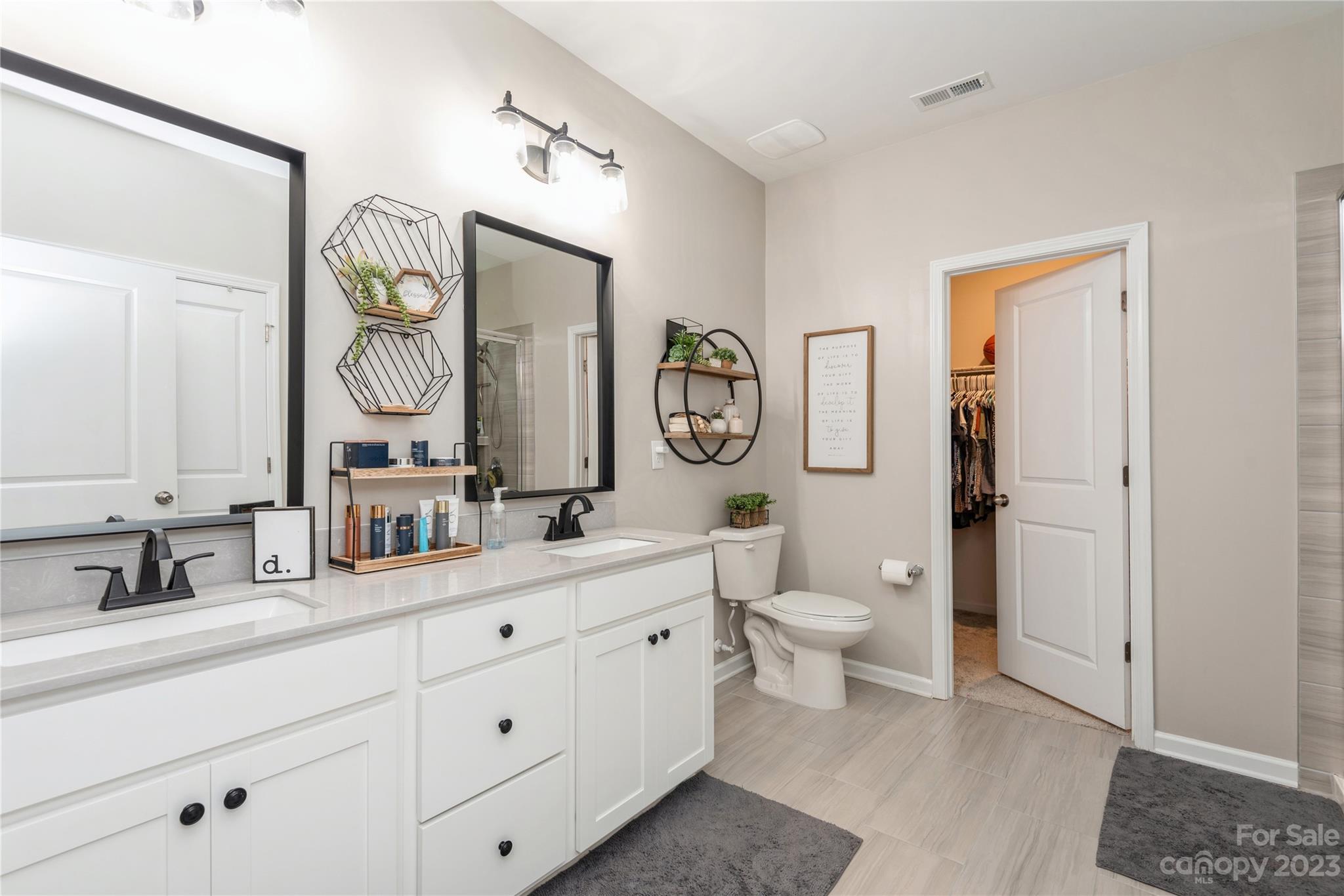 3028 Eagle Ridge Lane Indian Trail, NC 28079 - Photo 22 of 38 a spacious bathroom with a double vanity sink and a mirror
