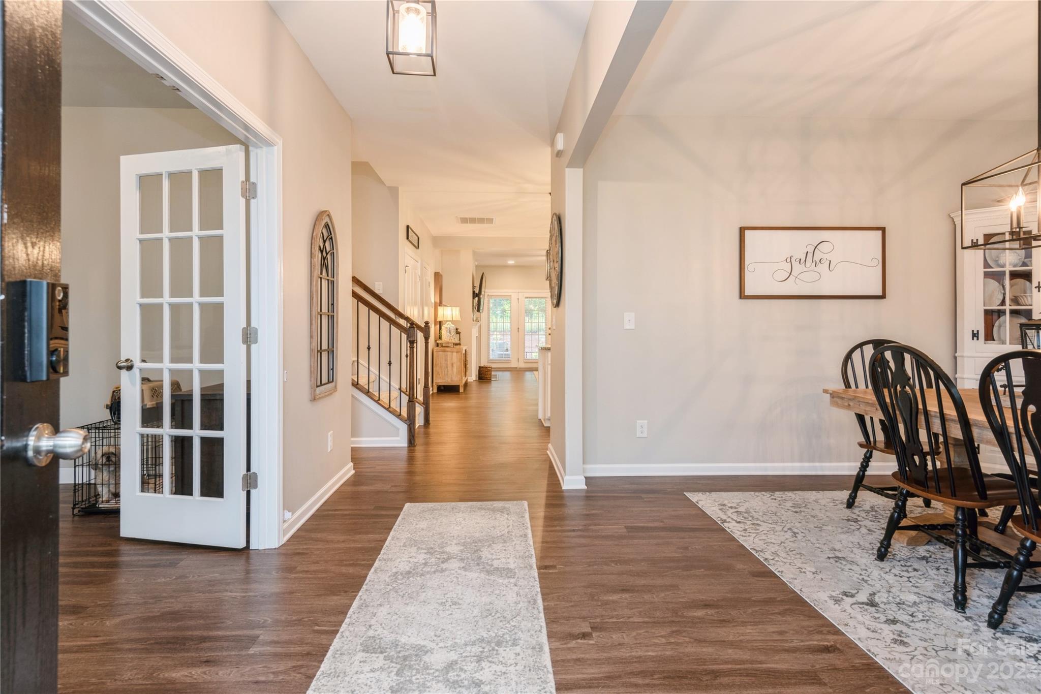 3028 Eagle Ridge Lane Indian Trail, NC 28079 - Photo 3 of 38 a view of a hallway with wooden floor and dining room