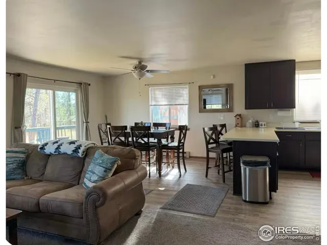 a living room with furniture a large window and a dining table