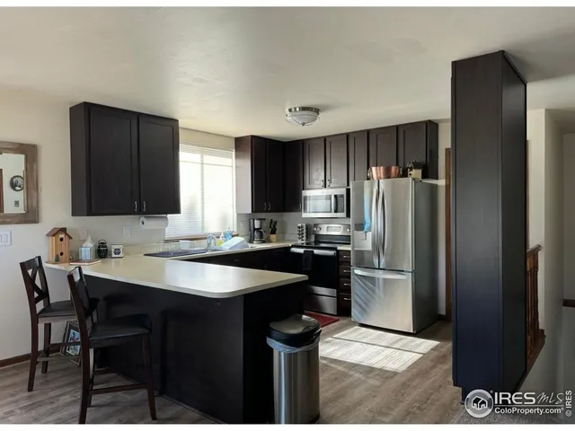 a kitchen with a sink a refrigerator and chairs