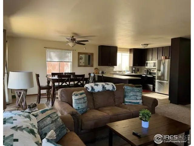 a living room with furniture a flat screen tv and a dining table