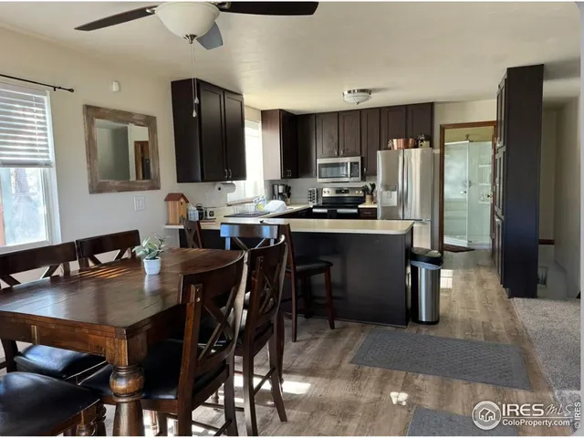 a kitchen with a table chairs refrigerator and cabinets