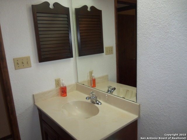 5878 Cliff Path San Antonio, TX 78250 - Photo 12 of 12 a bathroom with a sink and a mirror
