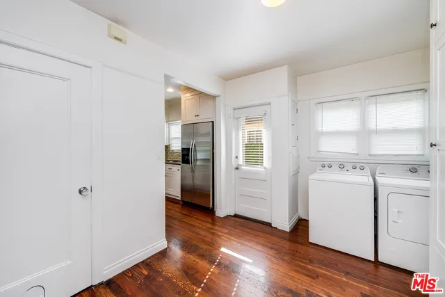 a view of a room with wooden floor and electronic appliances