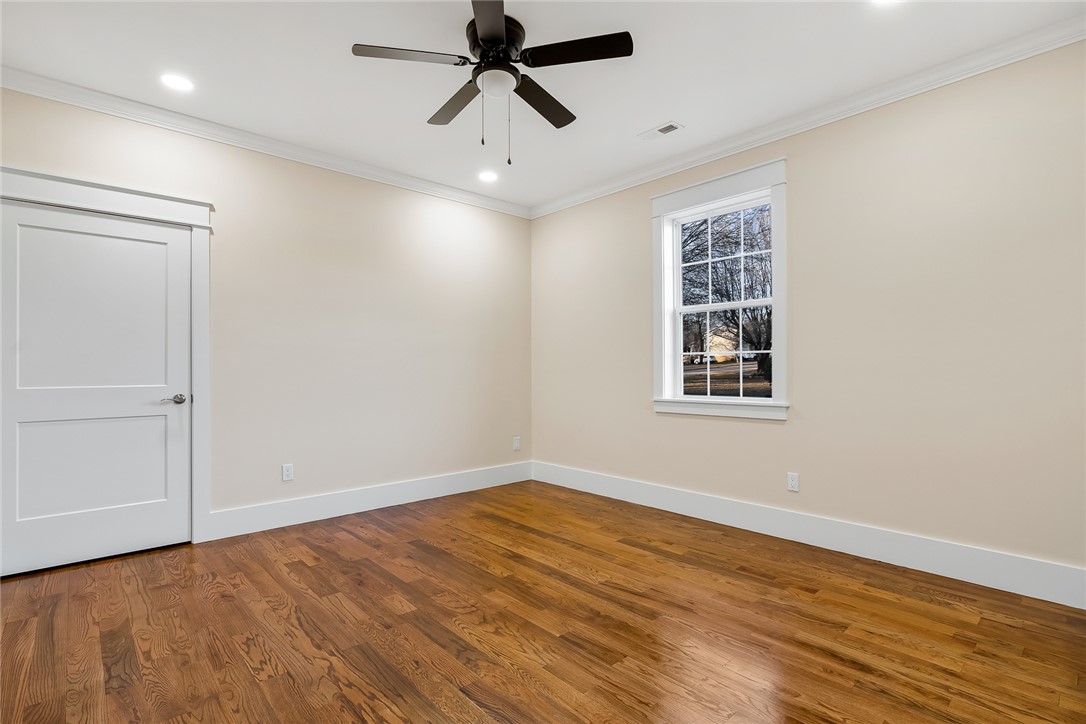 303 Regency Circle Anderson, SC 29625 - Photo 37 of 50 This spacious bedroom offers abundant natural light and rich hardwood flooring, creating a warm, inviting atmosphere.
