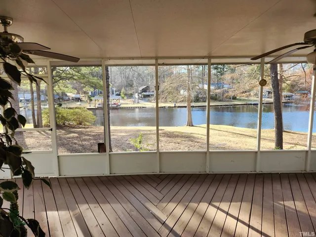 a view of an empty room with wooden floor and windows