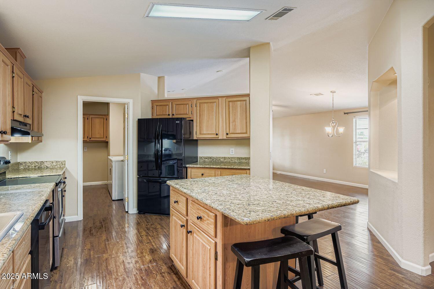 2550 South Ellsworth Road, Unit 277 Mesa, AZ 85209 - Photo 7 of 20 a kitchen with granite countertop kitchen island wooden cabinets a refrigerator stove and oven