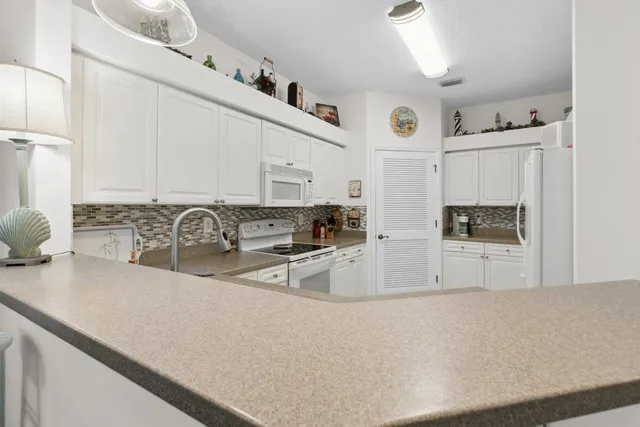 a view of a kitchen with stainless steel appliances granite countertop a sink and cabinets
