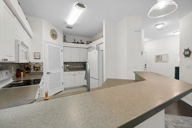 a kitchen with stainless steel appliances kitchen island granite countertop a refrigerator and a sink