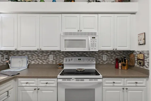 a kitchen with white cabinets and white appliances