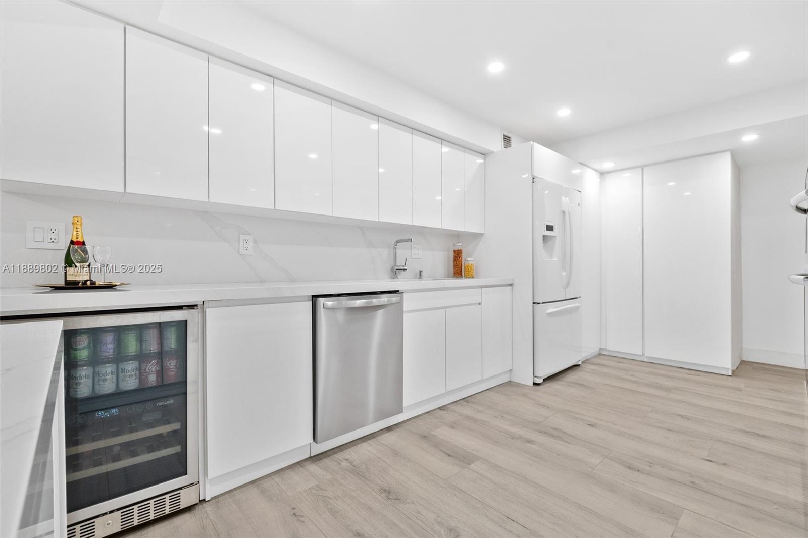1121 Crandon Boulevard, Unit D304 Key Biscayne, FL 33149 - Photo 10 of 42 a kitchen with white cabinets and white appliances