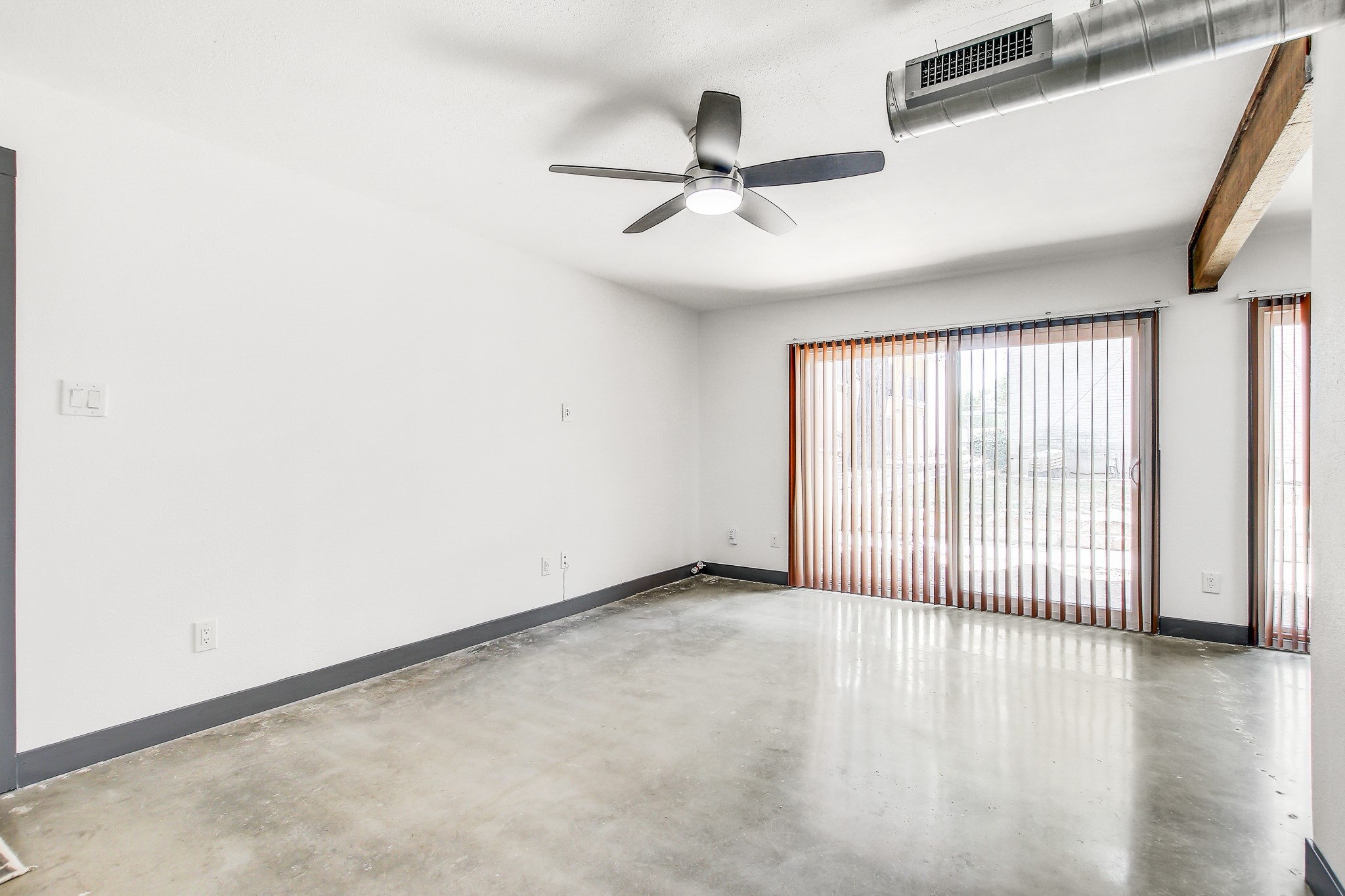 2124 Burton Drive, Unit 164 Austin, TX 78741 - Photo 4 of 37 an empty room with wooden floor fan and windows