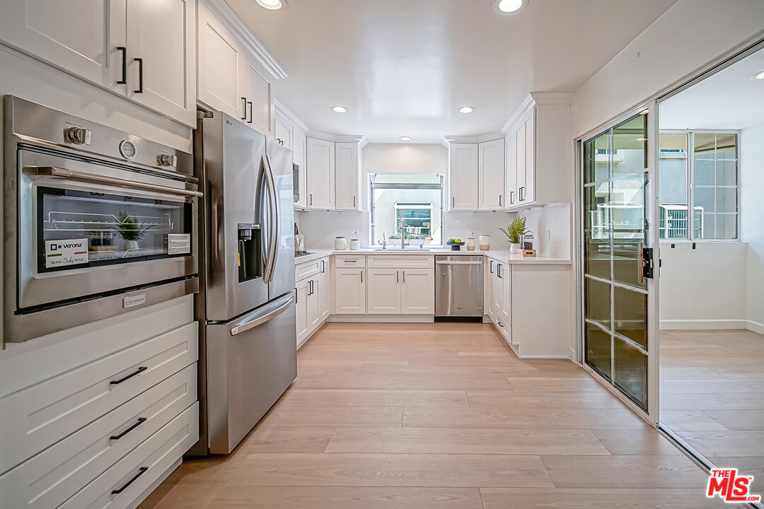 2950 South Bentley Avenue, Unit 3 Los Angeles, CA 90064 - Photo 12 of 32 a kitchen with white cabinets and white appliances