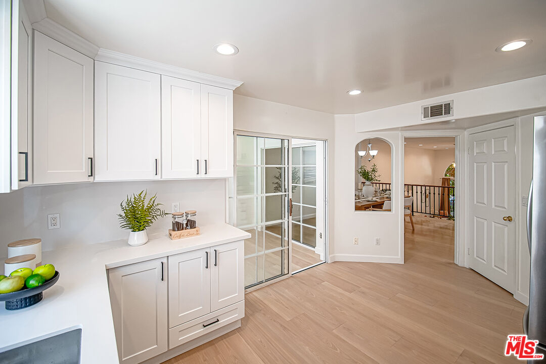 2950 South Bentley Avenue, Unit 3 Los Angeles, CA 90064 - Photo 15 of 32 a view of a kitchen with white cabinets and wooden floor