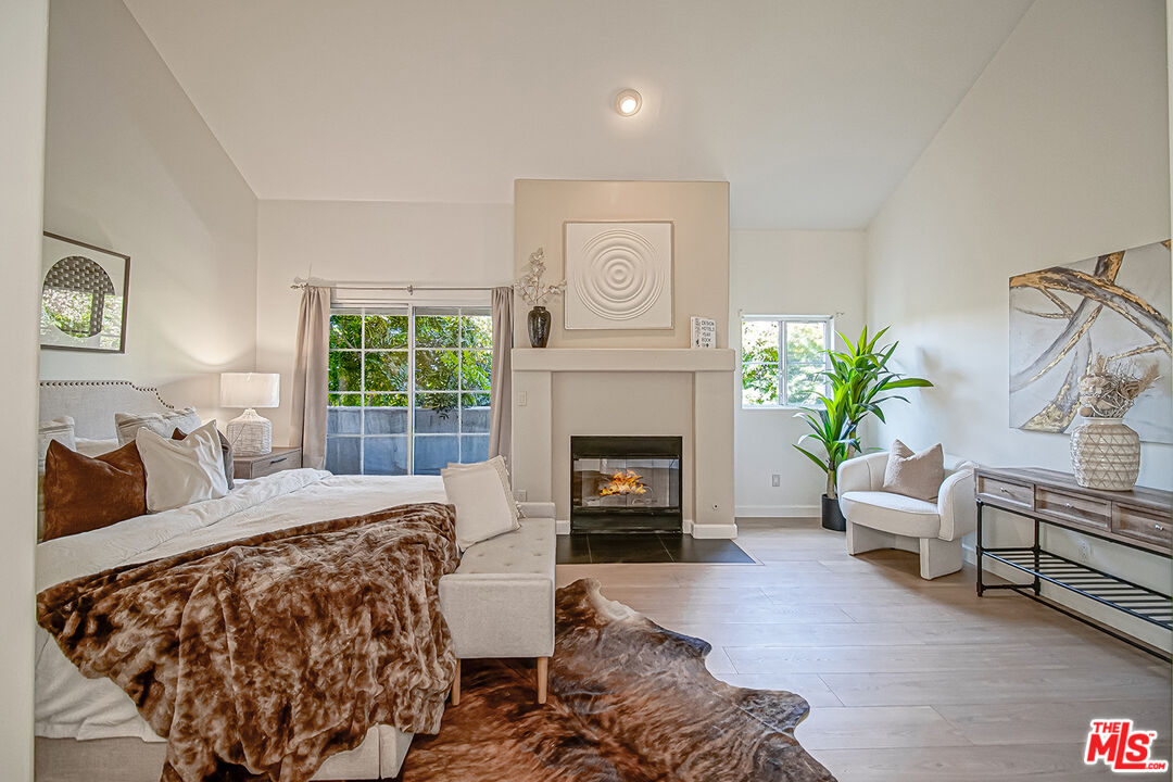 2950 South Bentley Avenue, Unit 3 Los Angeles, CA 90064 - Photo 18 of 32 a bedroom with furniture and a fireplace