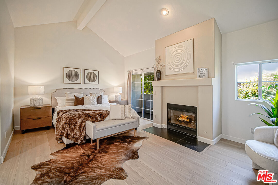 2950 South Bentley Avenue, Unit 3 Los Angeles, CA 90064 - Photo 19 of 32 a bedroom with a bed and a fireplace