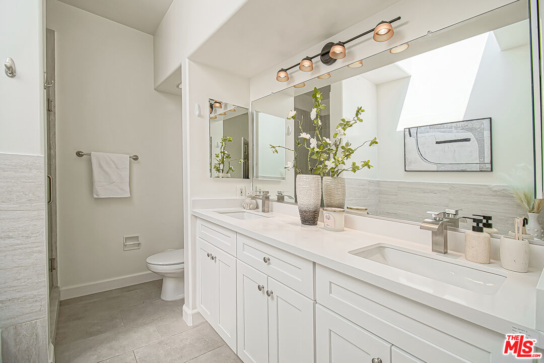 2950 South Bentley Avenue, Unit 3 Los Angeles, CA 90064 - Photo 22 of 32 a bathroom with a granite countertop sink mirror and toilet