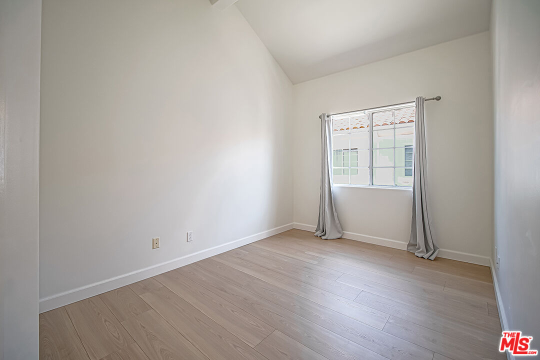 2950 South Bentley Avenue, Unit 3 Los Angeles, CA 90064 - Photo 27 of 32 an empty room with wooden floor and a window