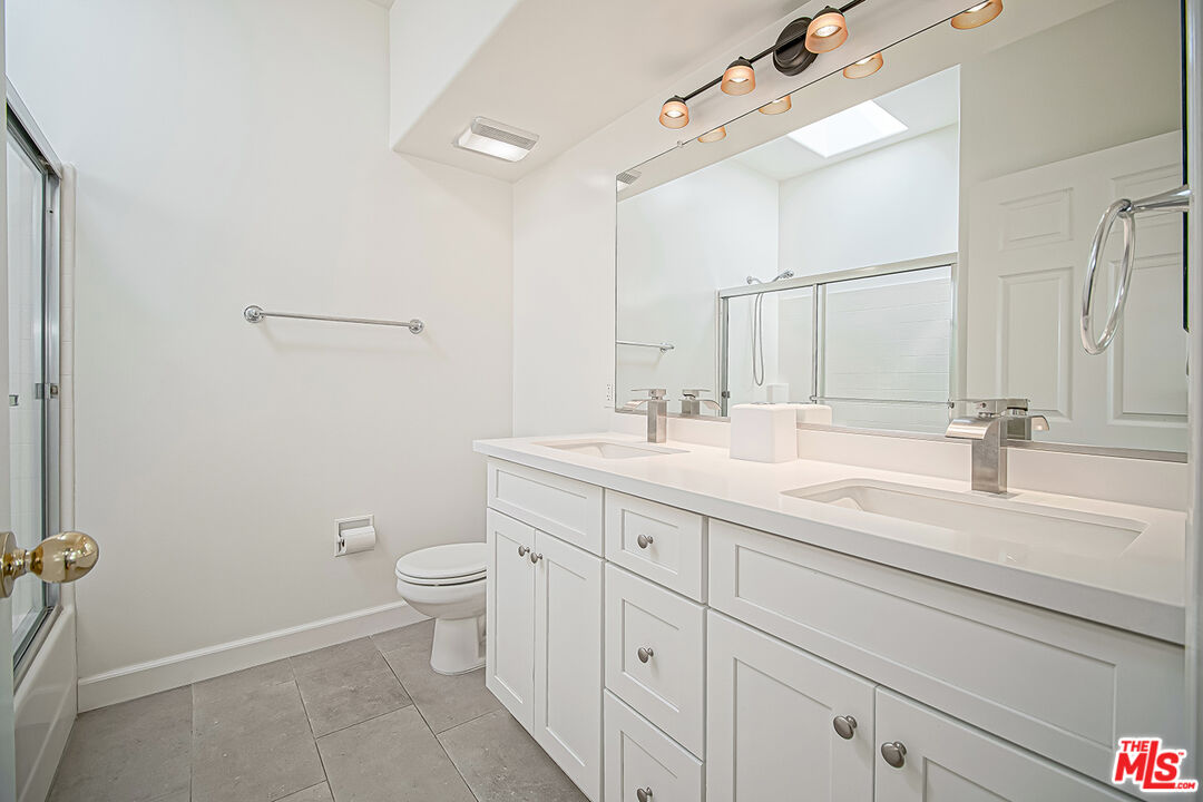 2950 South Bentley Avenue, Unit 3 Los Angeles, CA 90064 - Photo 28 of 32 a bathroom with a sink a toilet and a mirror