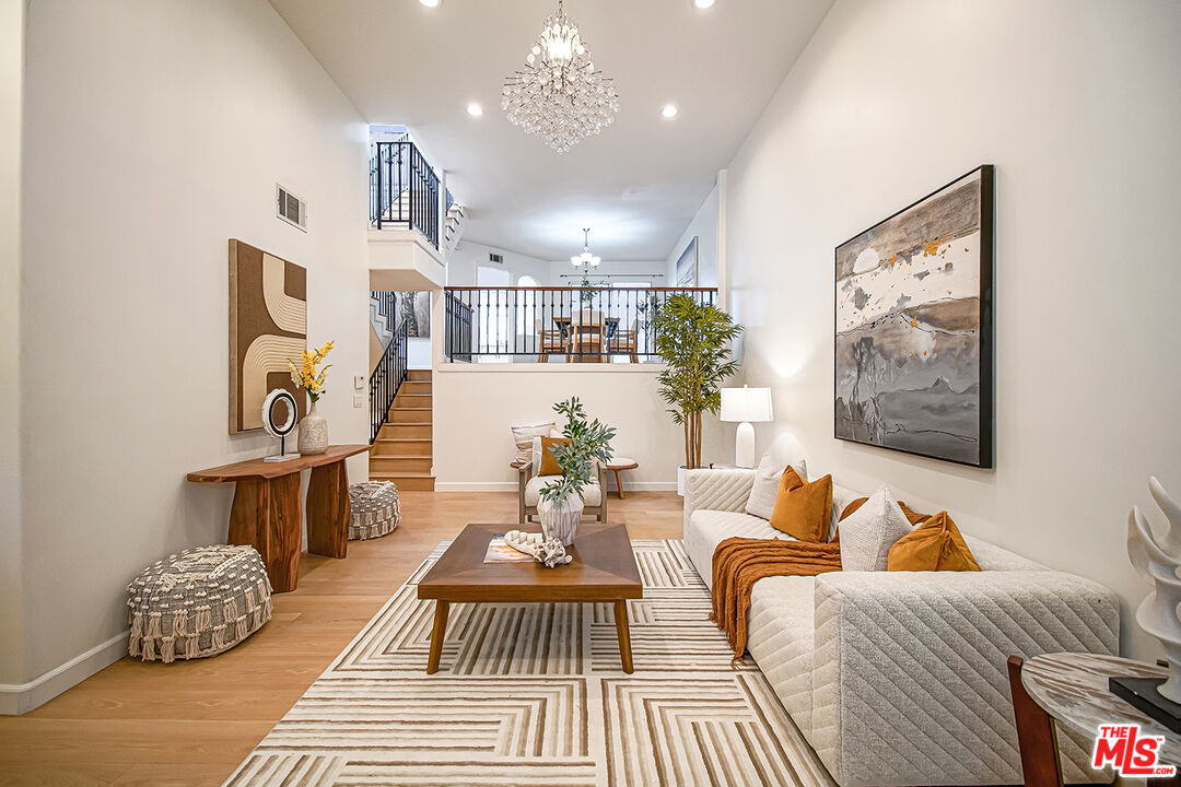 2950 South Bentley Avenue, Unit 3 Los Angeles, CA 90064 - Photo 4 of 32 a living room with furniture and a chandelier