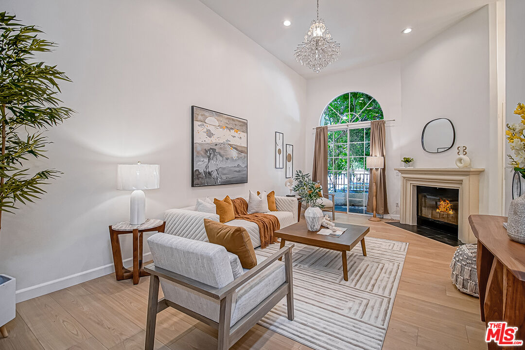 2950 South Bentley Avenue, Unit 3 Los Angeles, CA 90064 - Photo 5 of 32 a living room with furniture a fireplace and a chandelier