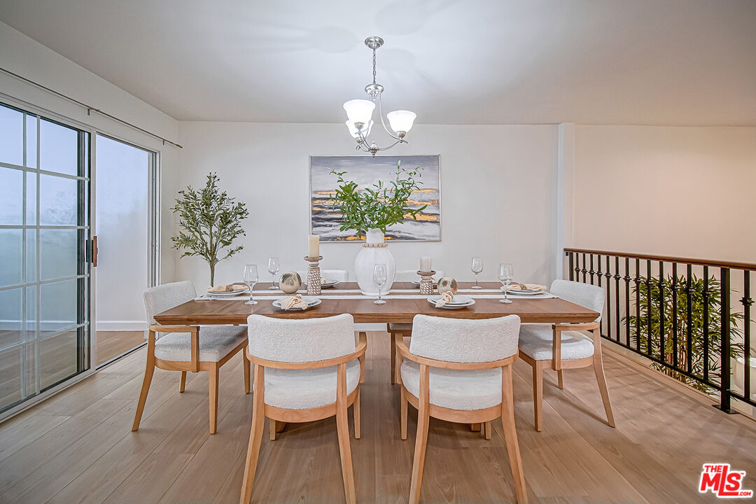 2950 South Bentley Avenue, Unit 3 Los Angeles, CA 90064 - Photo 8 of 32 a dining room with wooden floor a chandelier a glass table and chairs