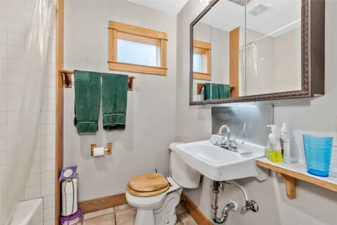 a bathroom with a sink toilet and mirror