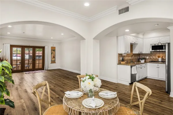 a kitchen with stainless steel appliances granite countertop a kitchen island hardwood floor and a sink