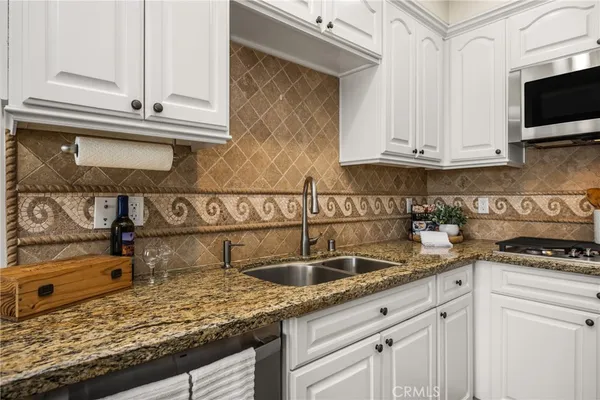 a kitchen with stainless steel appliances granite countertop a refrigerator a stove a microwave oven a sink with island and chairs