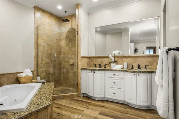 a bathroom with a granite countertop tub sink and mirror