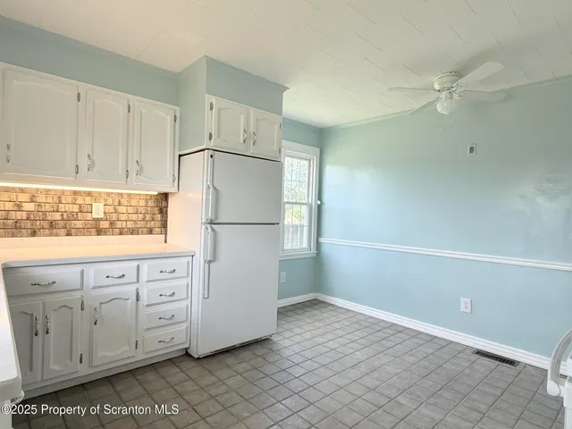 a kitchen with white cabinets and white appliances