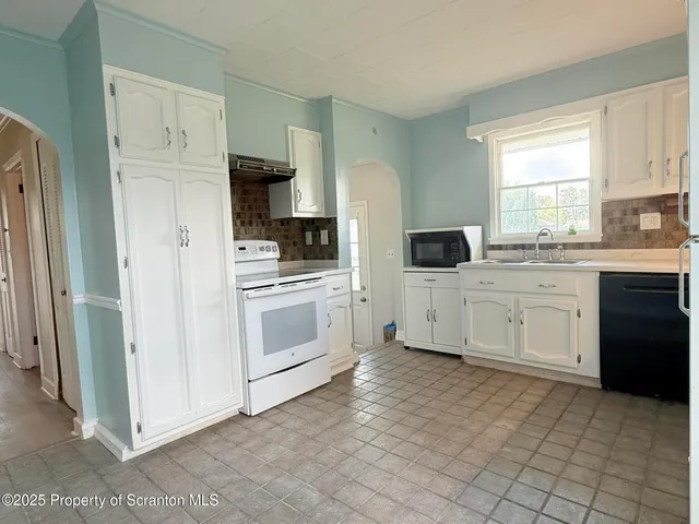 a kitchen with white cabinets and white appliances
