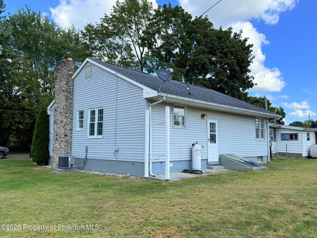 a backyard of a house with barbeque oven and brick wall