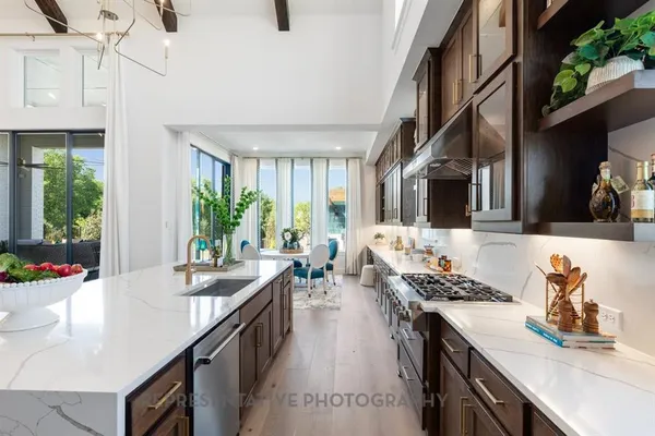 a kitchen with stove a sink dishwasher and cabinets with wooden floor