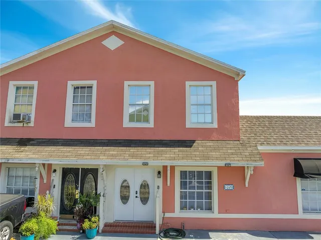 a living room with painting on the wall and a potted plant
