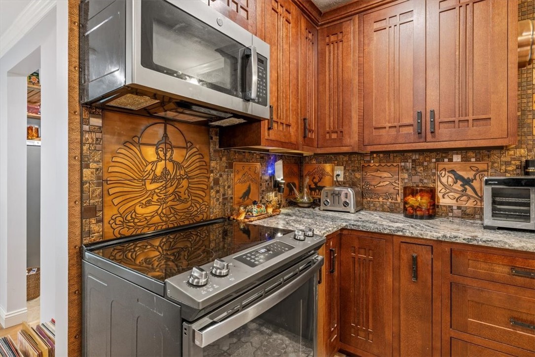 3496 3rd Place Vero Beach, FL 32968 - Photo 16 of 36 a kitchen with granite countertop a stove top oven microwave and cabinets