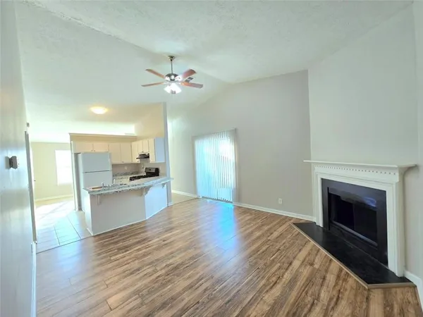 a view of a kitchen with a sink a kitchen counter top and a fireplace