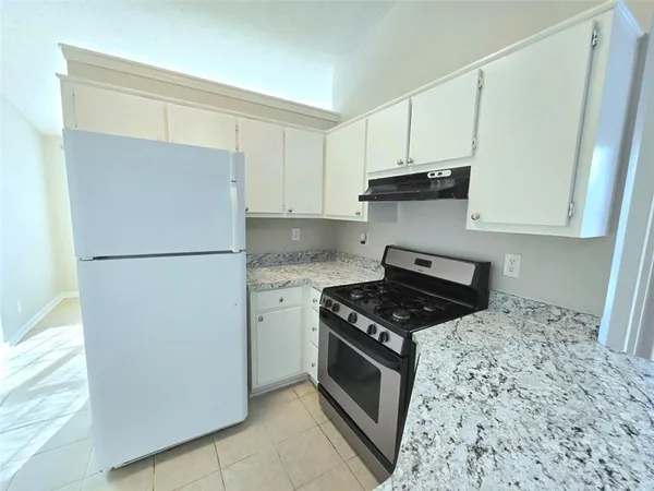 a kitchen with cabinets and a stove top oven