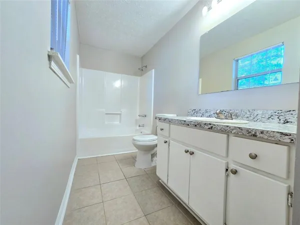 a bathroom with a granite countertop sink a toilet and a mirror