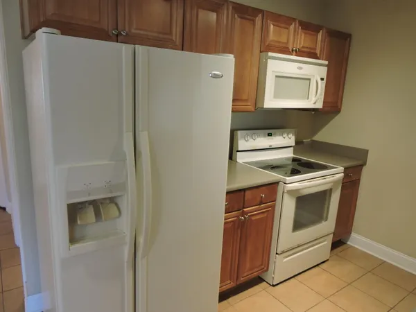 a white refrigerator freezer and a stove sitting inside of a kitchen