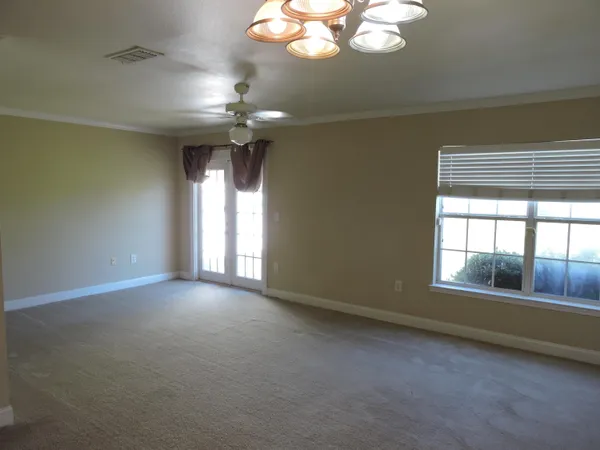 an empty room with a ceiling fan and a window