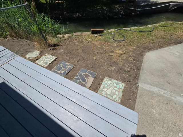 259 14th Street Ogden, UT 84404 - Photo 4 of 21 Wood-finish decking with stone pavers leading to a natural water feature